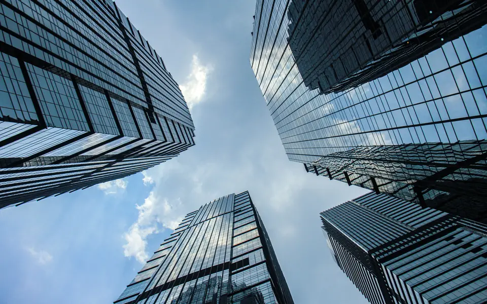 Glass office towers seen from below against a blue sky